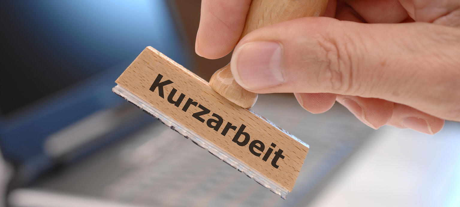 Holzstempel mit der Aufschrift Kurzarbeit